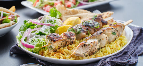 greek chicken souvlaki platter with pita bread, salad and rice